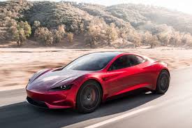 Voiture Tesla Roadster de couleur rouge roulant sur la route