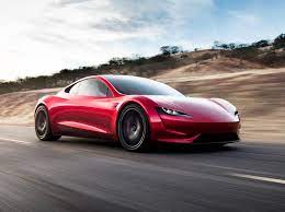 Voiture Tesla Roadster de couleur rouge roulant sur la route