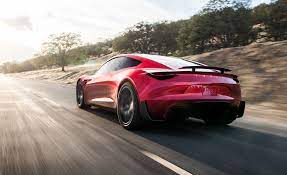 Voiture Tesla Roadster de couleur rouge roulant sur la route