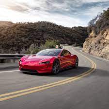 Voiture Tesla Roadster de couleur rouge roulant sur la route