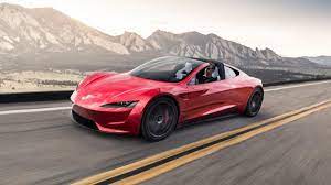 Voiture Tesla Roadster de couleur rouge roulant sur la route