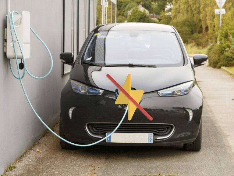 Véhicule électrique noir en rechargement avec une croix rouge dessus